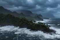 Storm clouds gathering over Hawaiian coastline as hurricane approaches