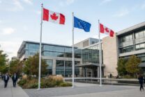 Canadian and European Union flags displayed together outside institutional building