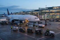 Ground crew workers servicing commercial aircraft at international airport terminal