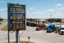 Diesel fuel price display at truck stop with commercial trucks refueling